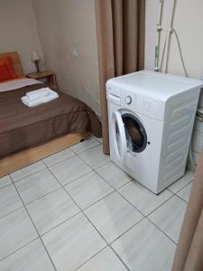 a room with a washing machine and a bed at Cosy Studio Down Town in Kavala