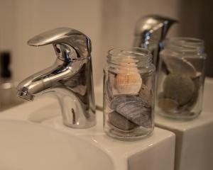 a glass jar with rocks in it next to a sink at Fisherman Guesthouse Sudureyri in Suðureyri