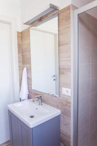 ein Bad mit einem Waschbecken und einem Spiegel in der Unterkunft Albergo Montenegro in Maniago