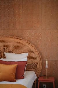 a bedroom with a wicker bed with pillows on it at Le Domaine de l'Hostellerie in Le Fresne-Camilly