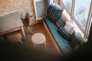 a living room with a green couch and a table at Le Domaine de l'Hostellerie in Le Fresne-Camilly