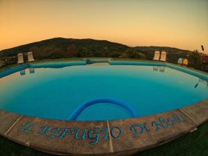 uma grande piscina azul com uma montanha ao fundo em B&B Il Rifugio di Nino em Contursi Terme