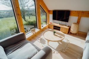 a living room with a table and a large window at Beavers Lodge. Luxury Property with Hot Tub in Tenby