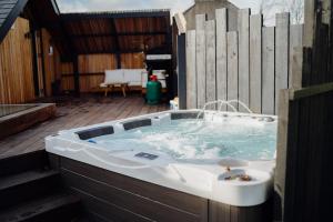 a bath tub sitting on top of a deck at Beavers Lodge. Luxury Property with Hot Tub in Tenby +22 photos