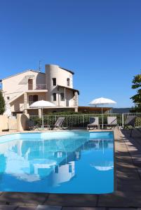 une grande piscine en face d'une maison dans l'établissement Hôtel de Vacances de la Vignasse, à Chandolas