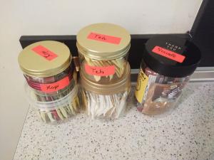 drie potten voedsel op een aanrecht met etiketten erop bij Alma Homestay 