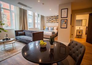 uma sala de estar com uma mesa e um sofá em The Gresham Aparthotel em Leicester