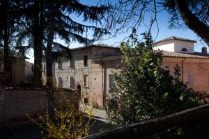 un vieux bâtiment avec un arbre en face dans l'établissement Relais B&B Corte Dei Turchi, à Longiano