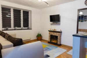 a living room with a couch and a fireplace at Angel House Central Aparament in Petroşani