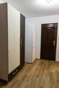 an empty room with a refrigerator and a door at Angel House Central Aparament in Petroşani