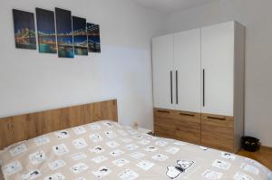 a bedroom with a bed and a painting on the wall at Angel House Central Aparament in Petroşani
