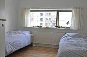 コペンハーゲンにあるApartmentInCopenhagen Apartment 417のベッドルーム1室(ベッド2台、窓付)