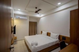 a bedroom with a white bed and a ceiling at HOTEL VENUS in Verāval
