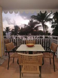 a table and chairs on a balcony with a view of the ocean at At home in Sainte-Anne