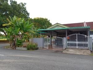 a building with a gate on the side of a street at SITI HOMESTAY D' TELOK KEMANG PORT DICKSON (MUSLIM HOMESTAY) in Port Dickson