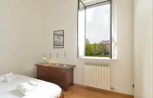 una camera bianca con un letto e una finestra di Argelati a Milano