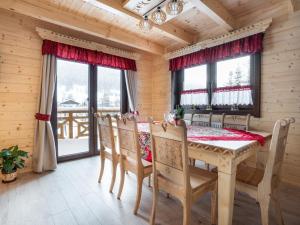 - une salle à manger avec une table, des chaises et des fenêtres dans l'établissement Domek Góralska Nuta, à Szczyrk