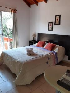 a bedroom with a large bed with a teddy bear on it at Complejo Sagrado Corazón in Merlo