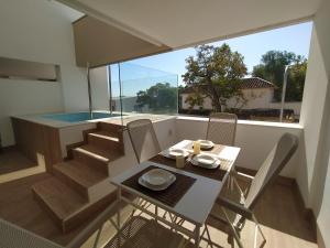 einen Tisch und Stühle auf einem Balkon mit Pool in der Unterkunft APARTAMENTO TERRAZAS DEL MAR, PISCINA PRIVADA in Torremolinos