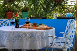una mesa con dos copas de vino y un plato de comida en Pousada Catavento, en Pipa