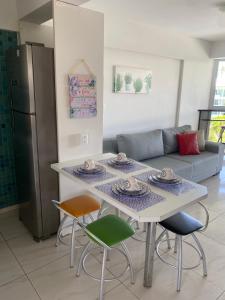cocina con mesa, sillas y sofá en Flats de 2 Quartos no Ancorar, en Porto de Galinhas