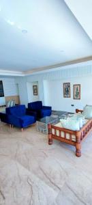 a living room with blue chairs and a couch at Hays Suites Hotel in Nairobi