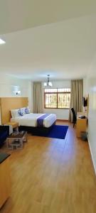 a large bedroom with a bed and a living room at Hays Suites Hotel in Nairobi