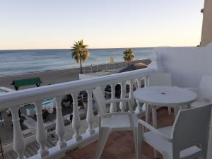 トレモリノスにあるApartamento Torremolinosの海を望むバルコニー(テーブル、椅子付)