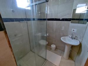 La salle de bains est pourvue d'une douche en verre et d'un lavabo. dans l'établissement Liv Hotel, à Porto Ferreira