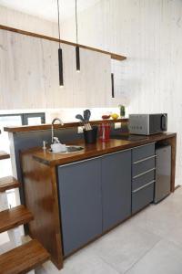 a kitchen with a counter with a sink and a microwave at Solo Lofts in El Chalten +8 photos