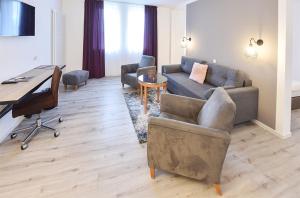 a living room with a couch and a desk at PRIMA Inn HOTEL & HOF NEURUPPIN - digitales & rezeptionsloses Motel in Neuruppin