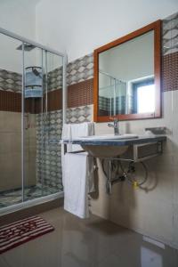 a bathroom with a sink and a shower with a mirror at Hotel 3M Tours in Vila Nova Sintra