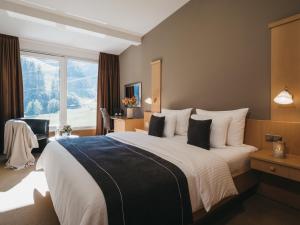 a hotel room with a large bed and a window at VAYA Zell am See in Zell am See