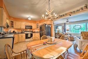 cocina y comedor con mesa de madera en Rustic Adirondacks Home with Hot Tub and Lake Access!, en Chestertown