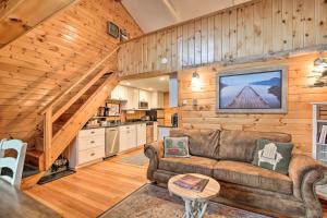 a living room with a couch and a staircase at Pet-Friendly Adirondack Cabin with On-Site Lake in Saranac Lake