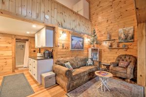 a living room with a couch and a table at Pet-Friendly Adirondack Cabin with On-Site Lake in Saranac Lake