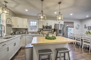 a kitchen with white cabinets and a kitchen island with stools at Renovated Lynchburg House about 2 Mi to Downtown! in Lynchburg