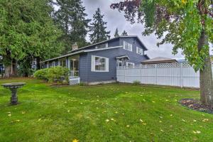 a blue house with a white fence in a yard at Spacious Home with Yard, 20 Miles to Olympic NP in Sequim
