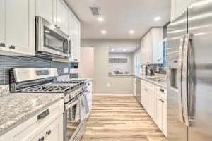 a kitchen with white cabinets and stainless steel appliances at Walk to UF Remodeled Family Home with Patio! in Gainesville