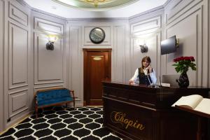 una mujer hablando por teléfono en el vestíbulo de un hotel en Chopin Hotel en Leópolis