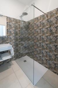 uma casa de banho com uma cabina de duche em vidro e um lavatório. em MOTEL CIRCUIT DRIVE em Cingia deʼ Botti