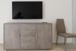 a television on top of a dresser with a chair at MOTEL CIRCUIT DRIVE in Cingia deʼ Botti