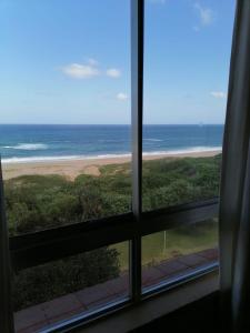 a view of the beach from a window at Amanzimtoti Afsaal Holiday Letting in Amanzimtoti