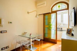 羅馬的住宿－La Petite Maison Piave，一间设有玻璃桌和彩色玻璃窗的用餐室