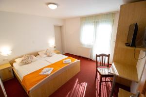 
a hotel room with a bed and a television at Rooms Cvitar - Center in Kranjska Gora
