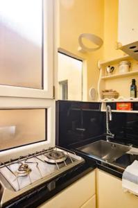 een keuken met een fornuis en een wastafel bij La Petite Maison Piave in Rome