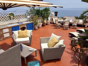 un patio con sillas, mesas y chimenea en Casa Aricò & Shatulle Suites, en Taormina