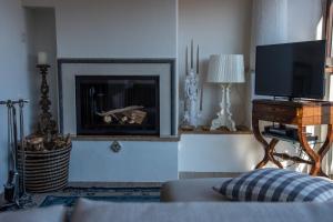 un soggiorno con camino e TV di Casa Aricò & Shatulle Suites a Taormina