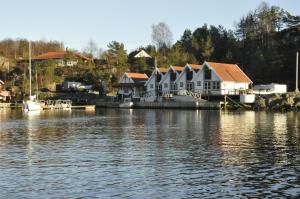 una casa en un muelle junto a un cuerpo de agua en Aasheim Rorbuer, en Bømlo