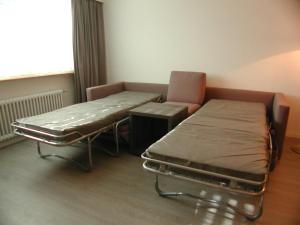 ein Krankenhauszimmer mit einem Bett und einem Stuhl in der Unterkunft Brunegghorn 4 in Grächen